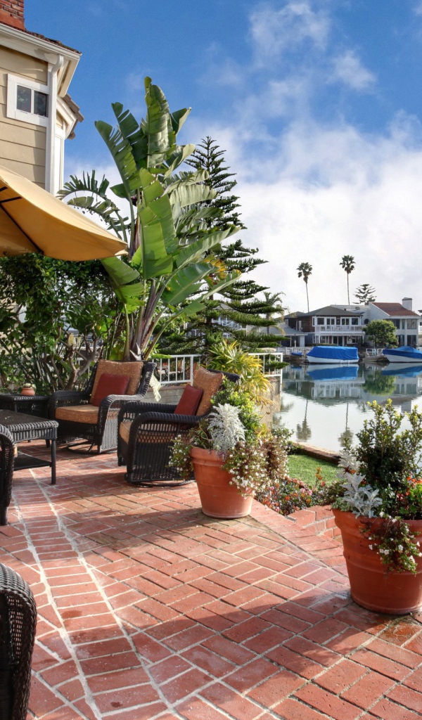 Плетеные кресла и цветы в горшках у набережной