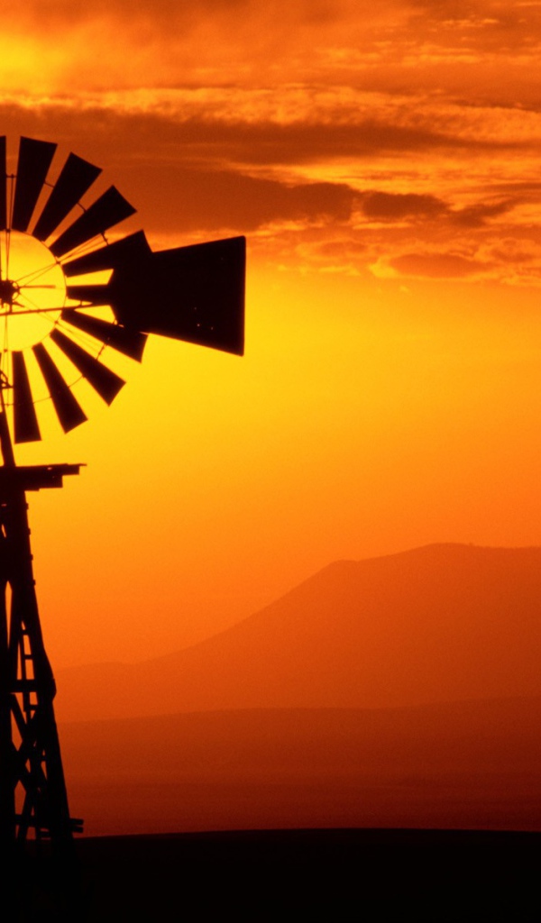 Ветряк флюгер на фоне заката, США