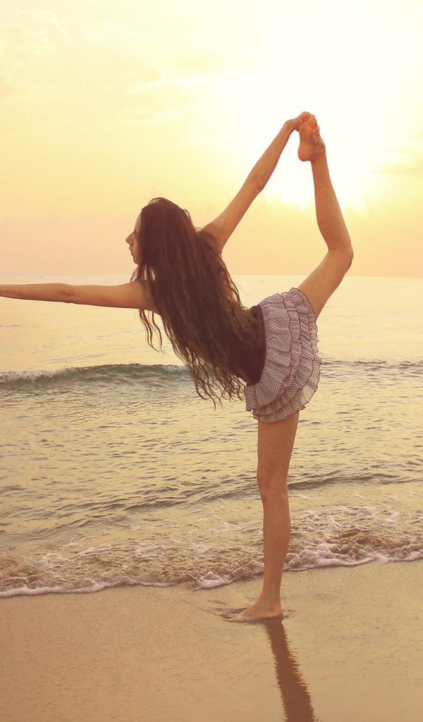 Балерина на берегу моря с птицей