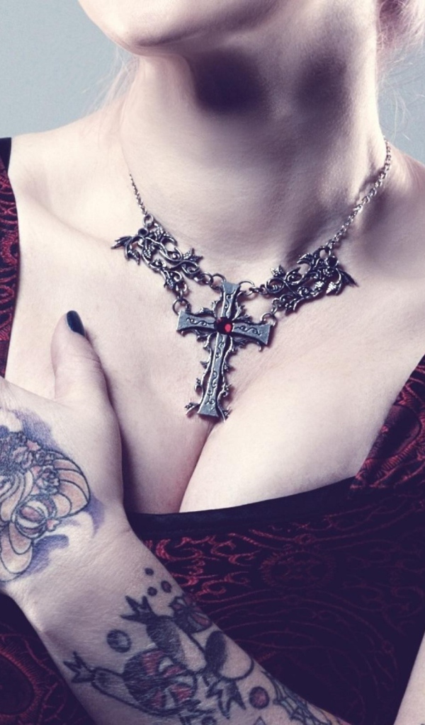 Красивый кулон на груди татуированной девушки