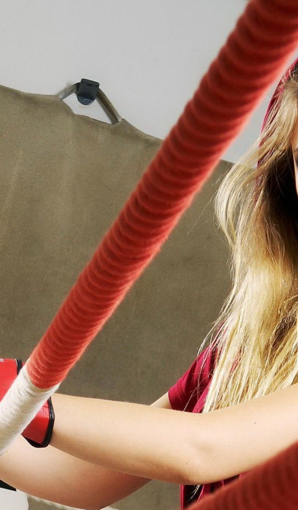 Блондинка в перчатках на боксерском ринге