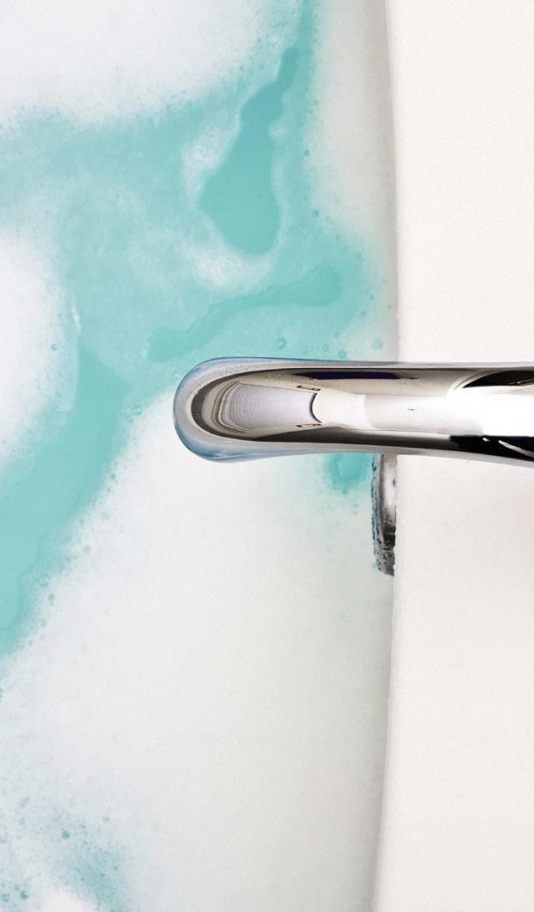 Кран над ванной с голубой водой