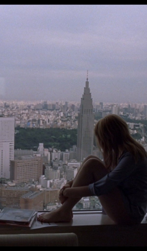 Девушка Скарлетт Йоханссон смотрит на город в окно