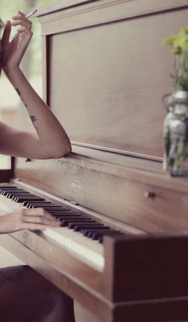Девушка с тату играет на пианино