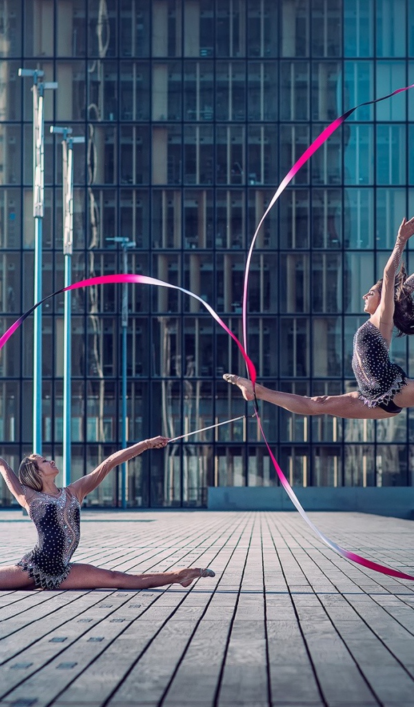 Гимнастки с лентами на площади перед небоскребом