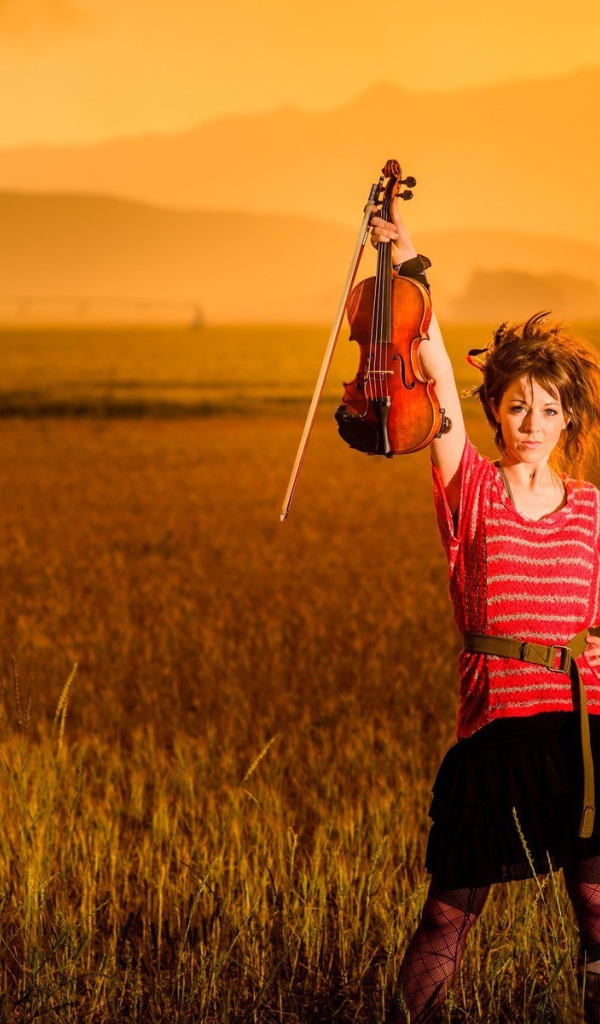 Скрипачка Линдси Стирллинг стоит в поле