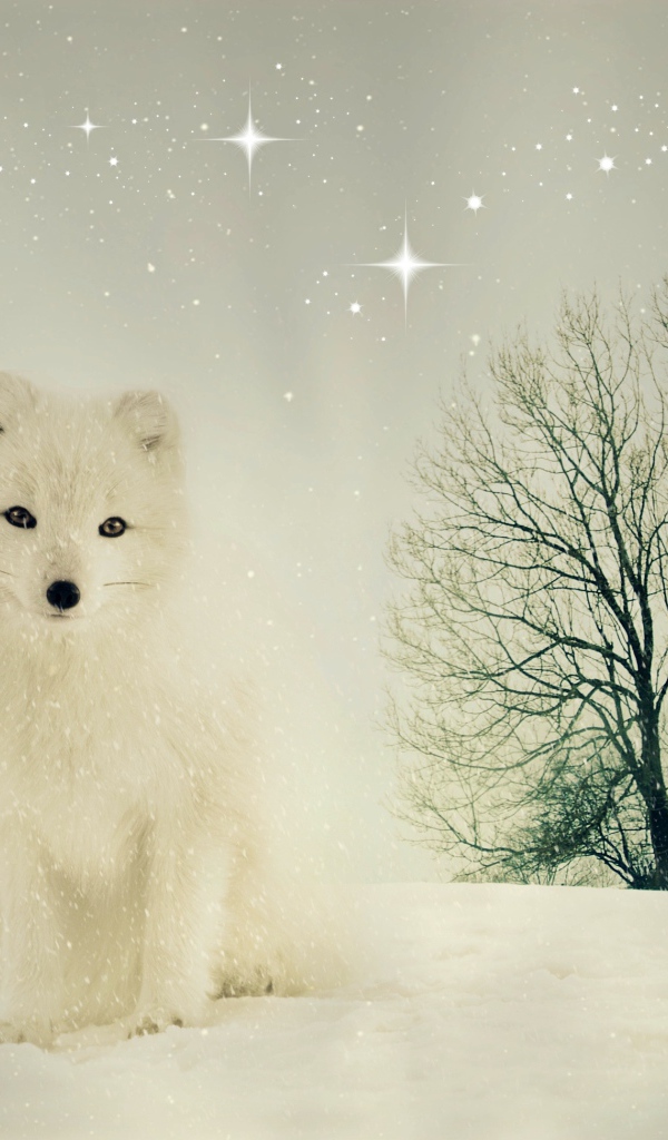 Белый песец сидит на снегу у сухого дерева