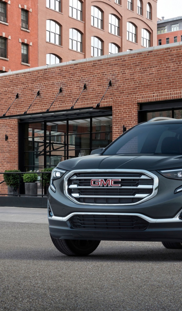 Серый внедорожник GMC Terrain на фоне здания
