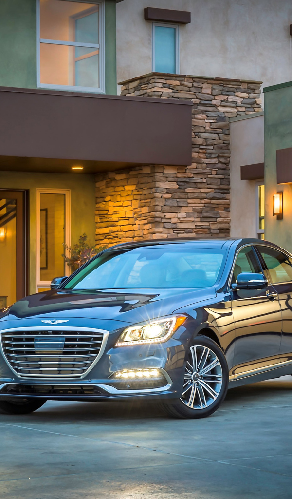 Серебристый автомобиль Genesis G80 с включенными фарами