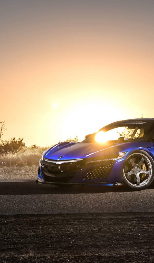 Blue sports car Acura NSX, 2017 in the background of a bright sun
