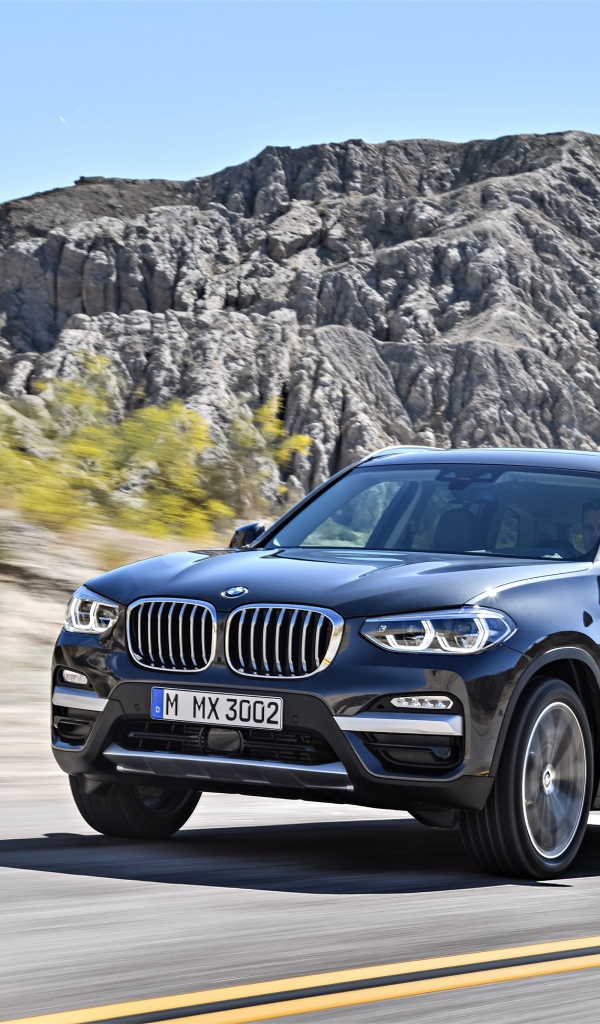 Черный красивый автомобиль BMW X3, 2018 на фоне гор