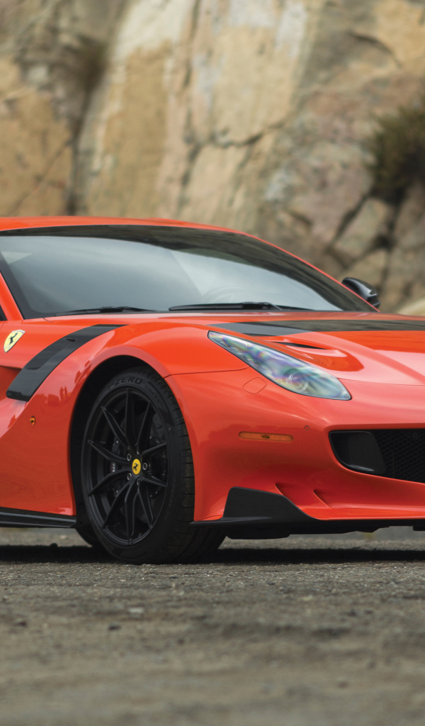 Красный спортивный автомобиль Ferrari F12tdf, 2017 у скалы