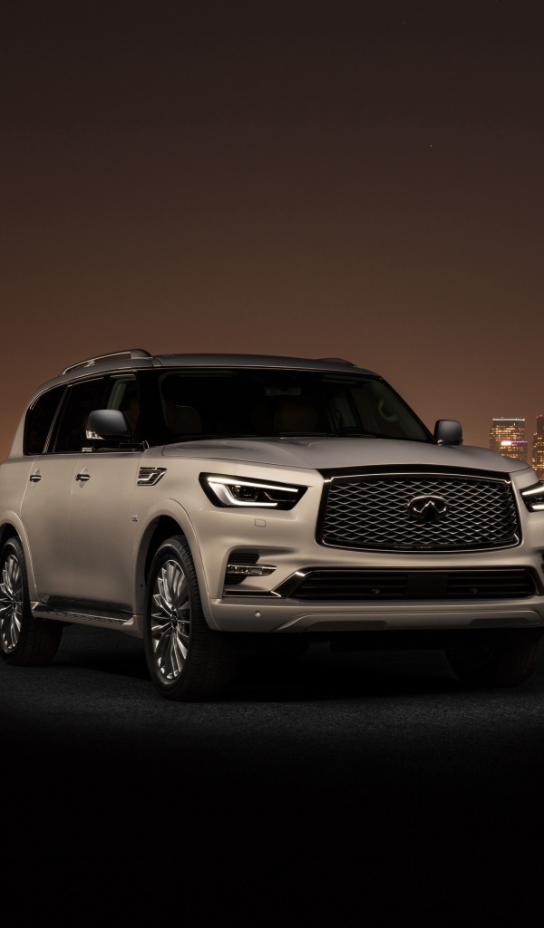 Автомобиль Infiniti QX80 2018 на фоне ночного города