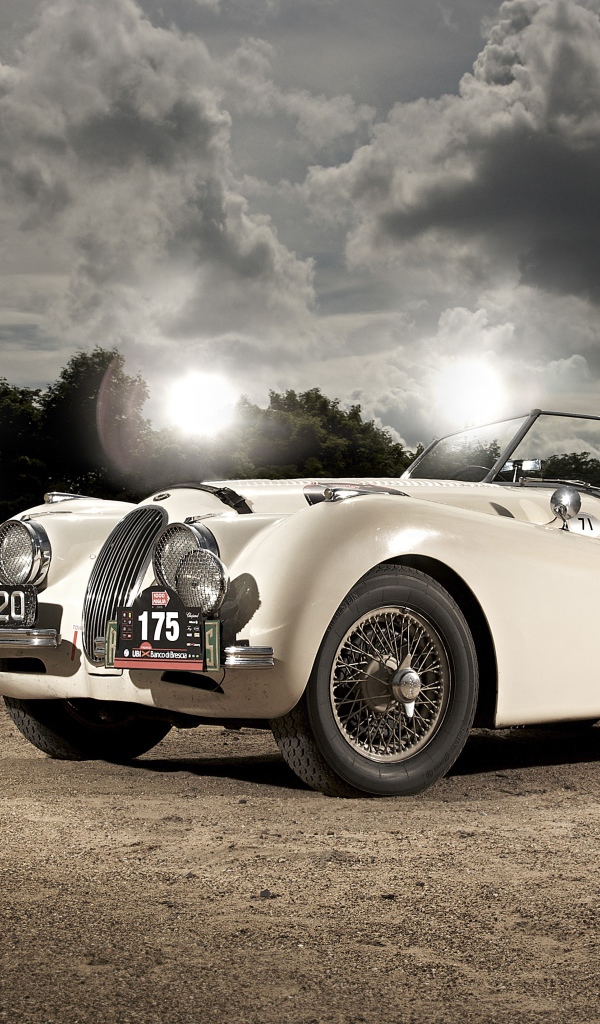 Белый спортивный ретро автомобиль Jaguar XK120, 1950 года