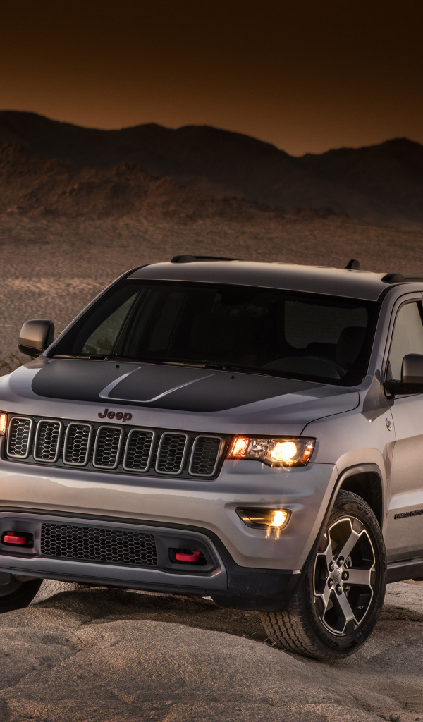 Серебристый внедорожник Jeep Grand Cherokee в пустыне 