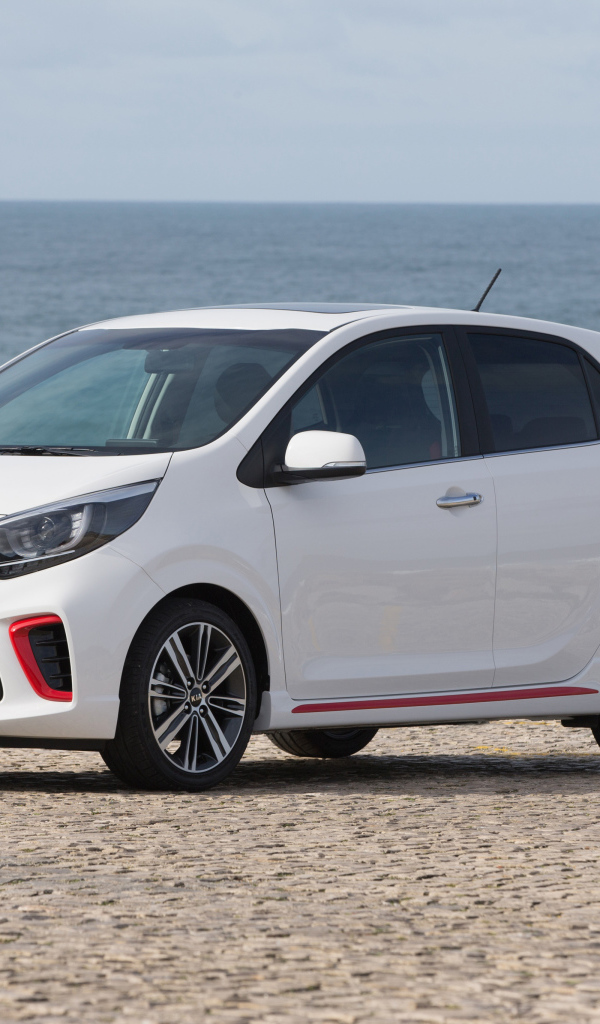 Белый автомобиль KIA Picanto GT Line, 2017 на фоне океана 