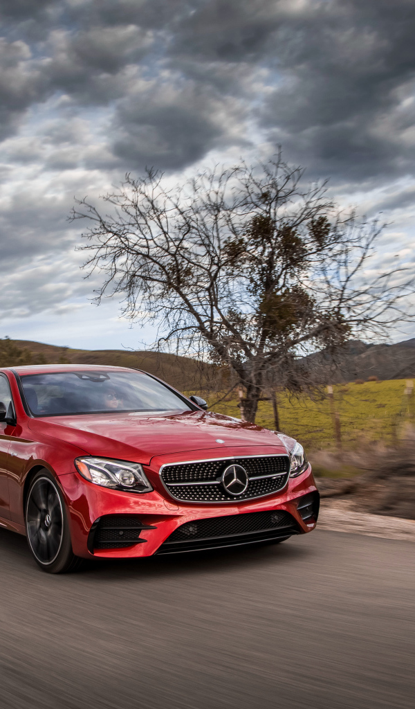 Стильный красный автомобиль Mercedes-Benz E-Class на фоне неба 