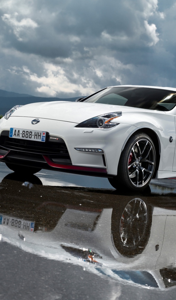 Белый автомобиль Nissan 370z Nismo, 2018 на фоне пасмурного неба