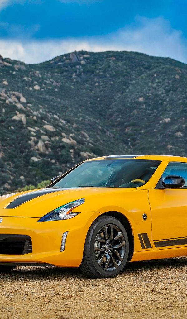 Желтый автомобиль Nissan 370Z Heritage Edition, 2018 на фоне гор