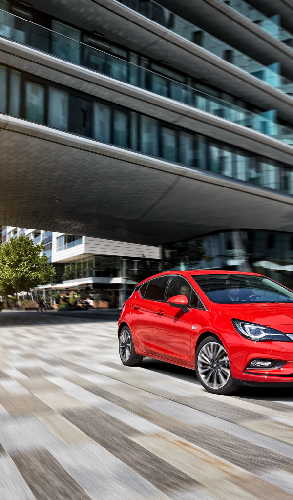 Красный автомобиль Opel Astra в движении