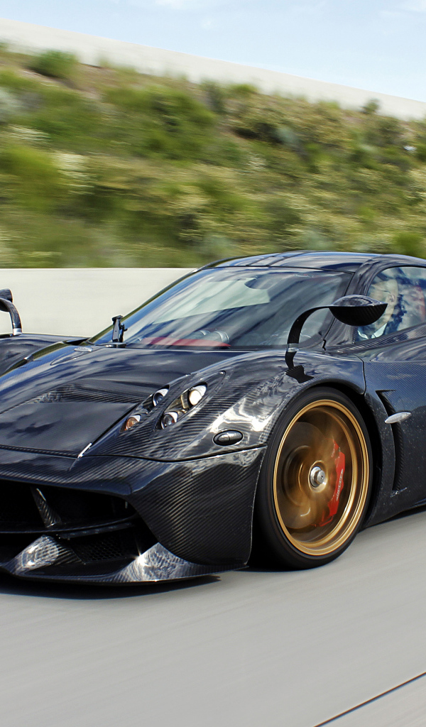 Черный спортивный автомобиль Pagani Huayra на трассе 