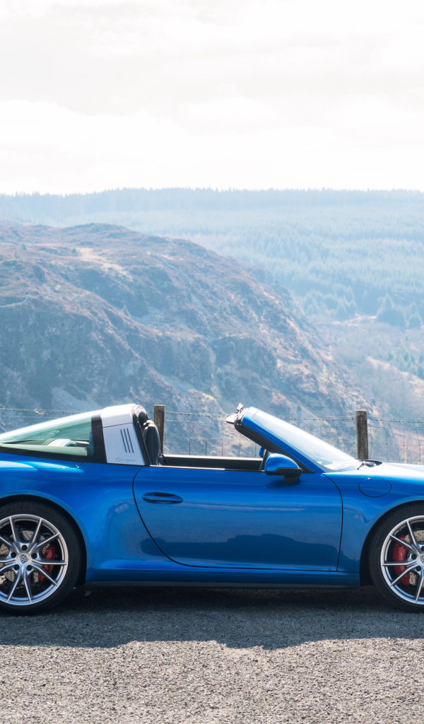 Голубой автомобиль кабриолет Porsche 911 Targa 4S на фоне гор