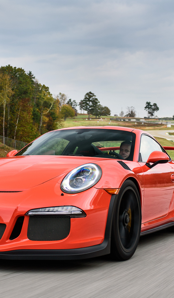 Оранжевый спортивный автомобиль Porsche 911 GT3 на трассе