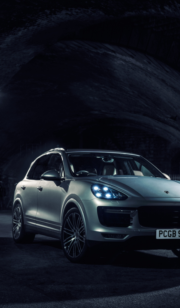 Silver Porsche Cayenne in a tunnel with lights on