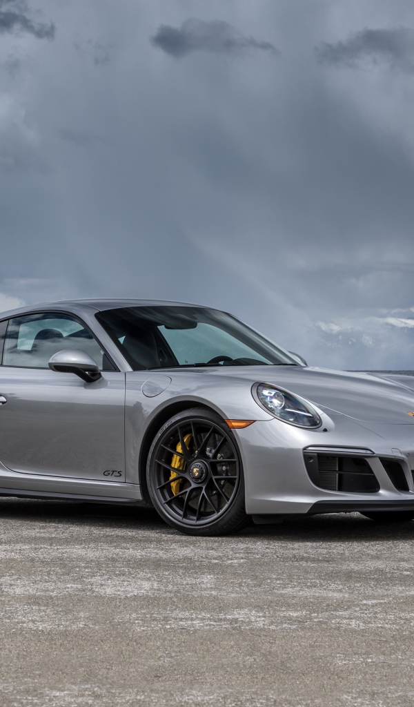 Серебристый автомобиль Porsche 911 Carrera 4 GTS Coupe на фоне грозового неба