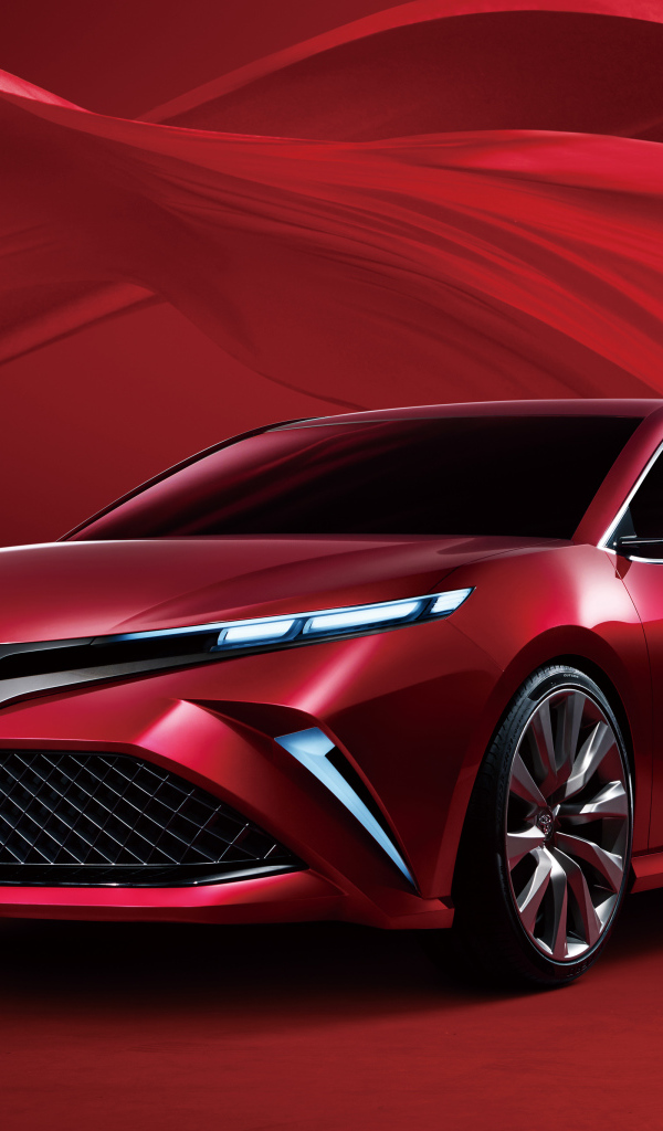 Красный автомобиль Toyota Camry, 2017 года на красном фоне 