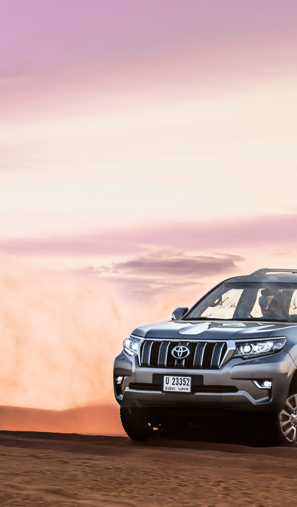 Серебристый внедорожник Toyota Land Cruiser Prado, 2018 едет по песку