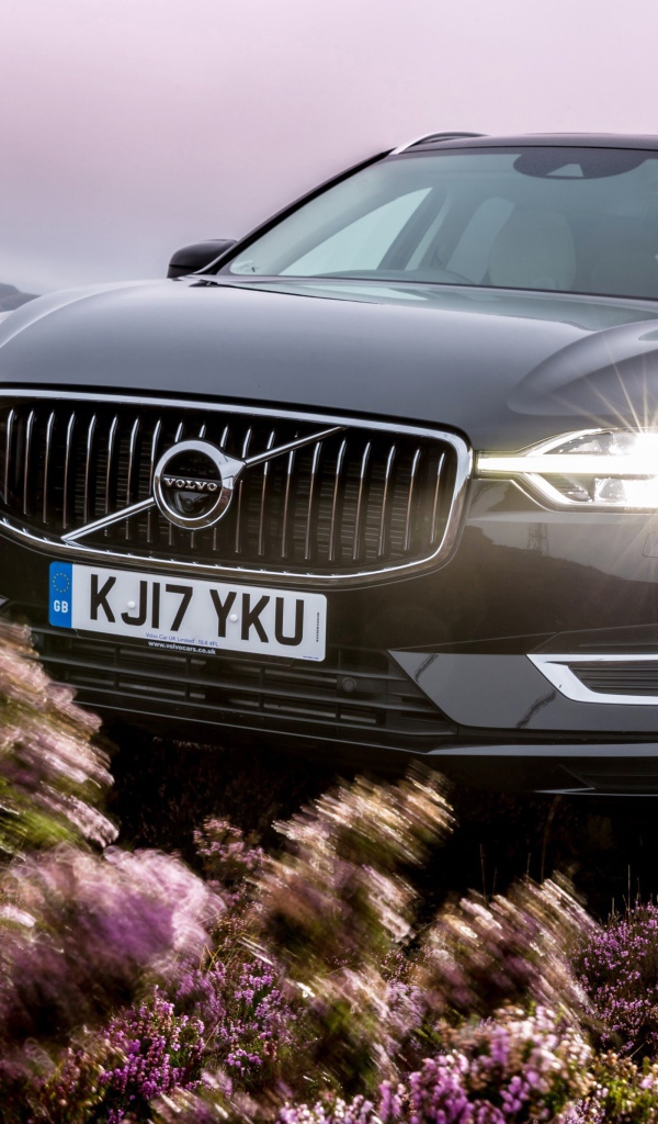 Черный автомобиль Volvo XC60 T8, 2018 с включенными фарами