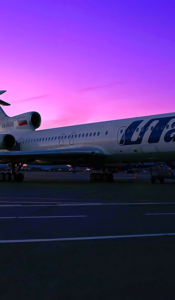Пассажирский самолет Ту-154 российской авиакомпании UTair на фоне заката 