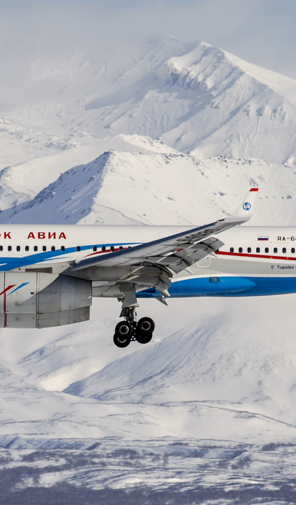 Самолет ТУ 204-300 авиакомпании Владивосток Авиа пролетает над горами Алтая 