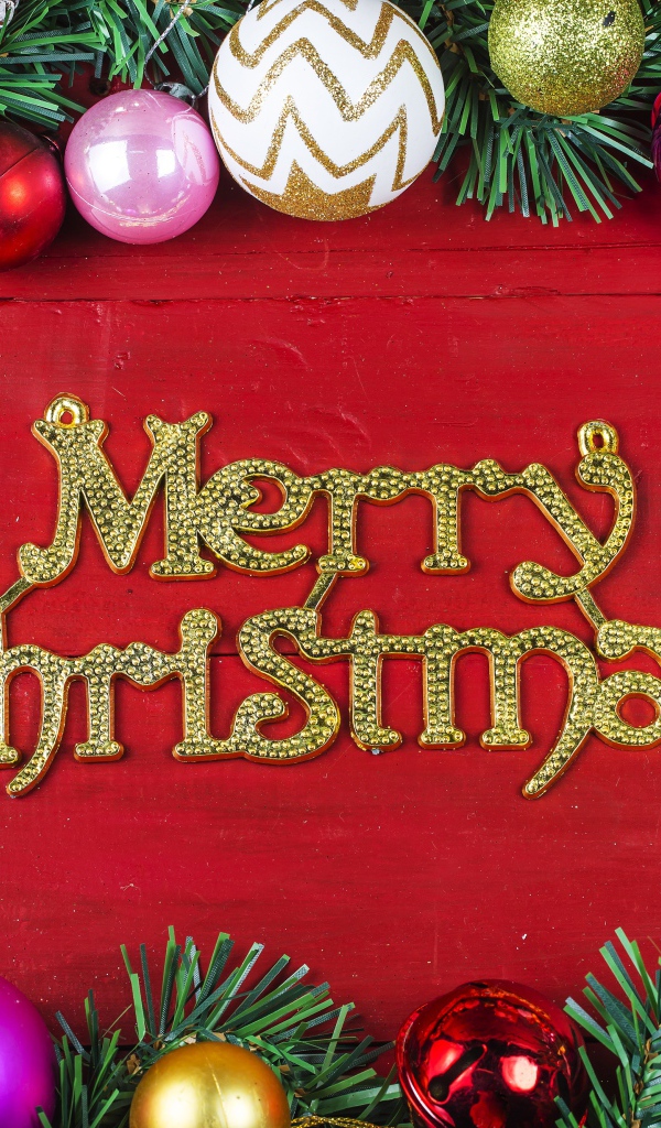 Надпись Merry Christmas на красном фоне с елочными игрушками на Рождество