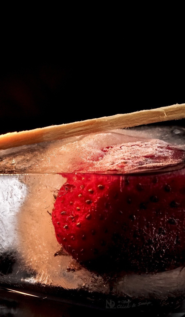 Зажженная спичка на кусочке льда с клубникой 