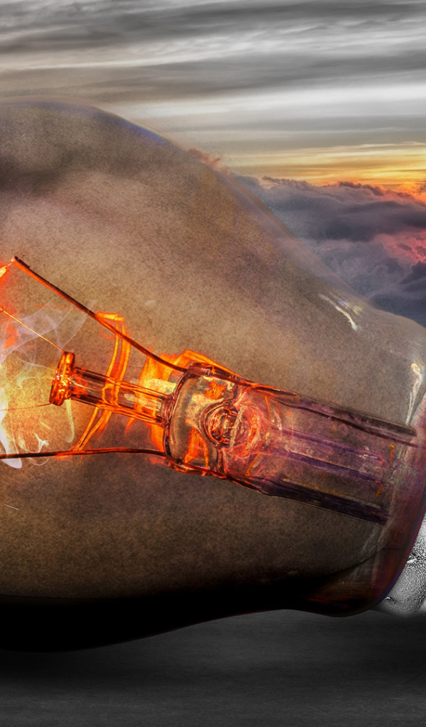 Раскаленная лампочка на фоне белых облаков в небе