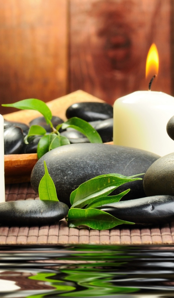 Черные камни дзен с двумя горящими свечами