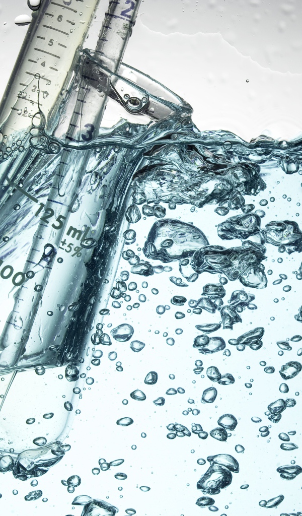 Измерительная чашка в воде с пузырями 