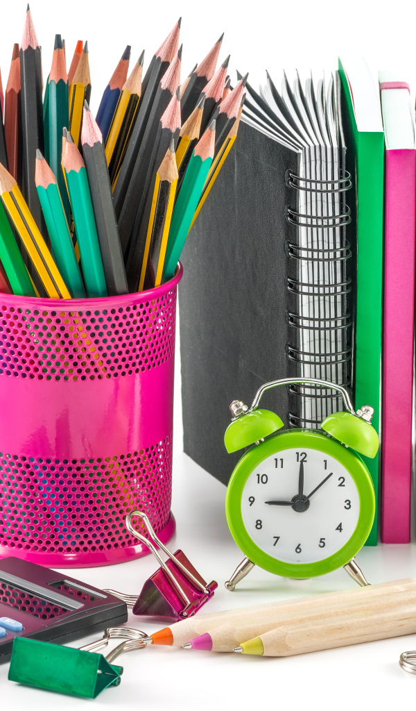 Канцелярские товары и красное яблоко на белом фоне