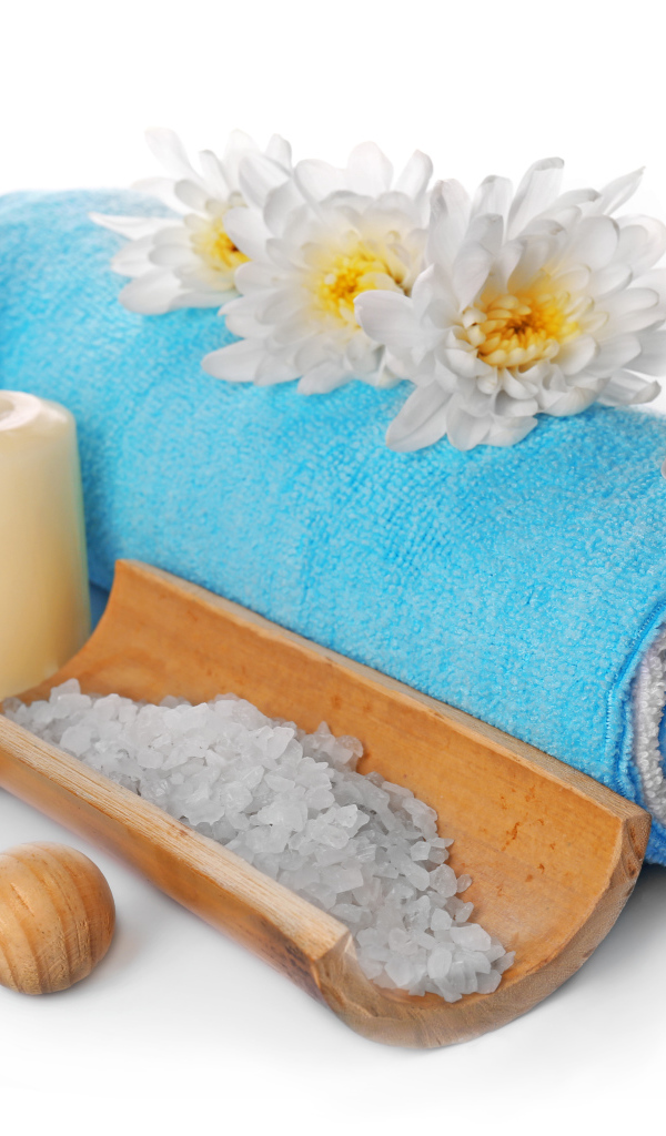 Полотенце, свечи, соль и цветы хризантемы на белом фоне