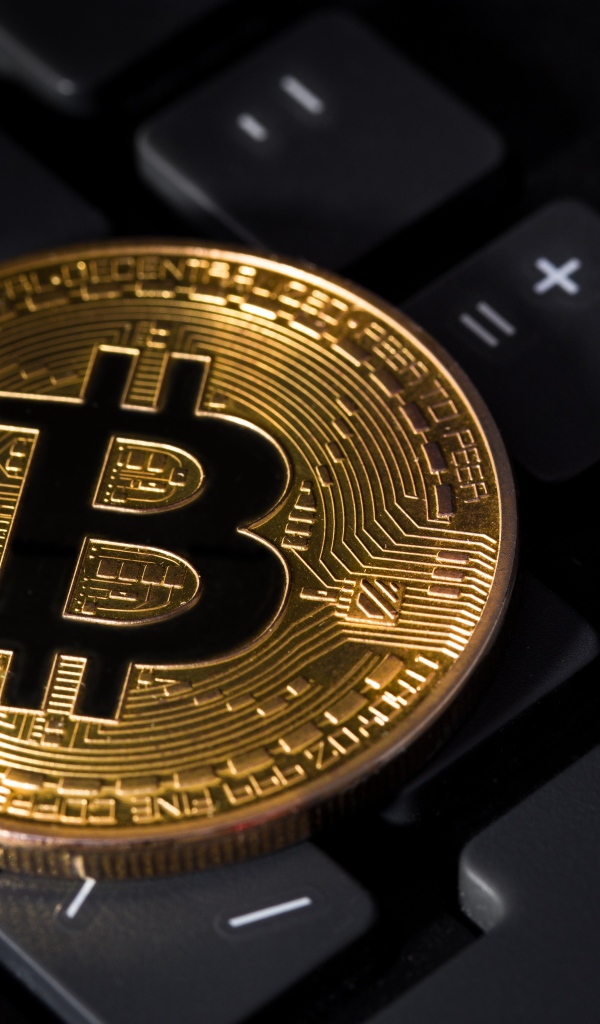 Coin bitcoin lies on a black keyboard
