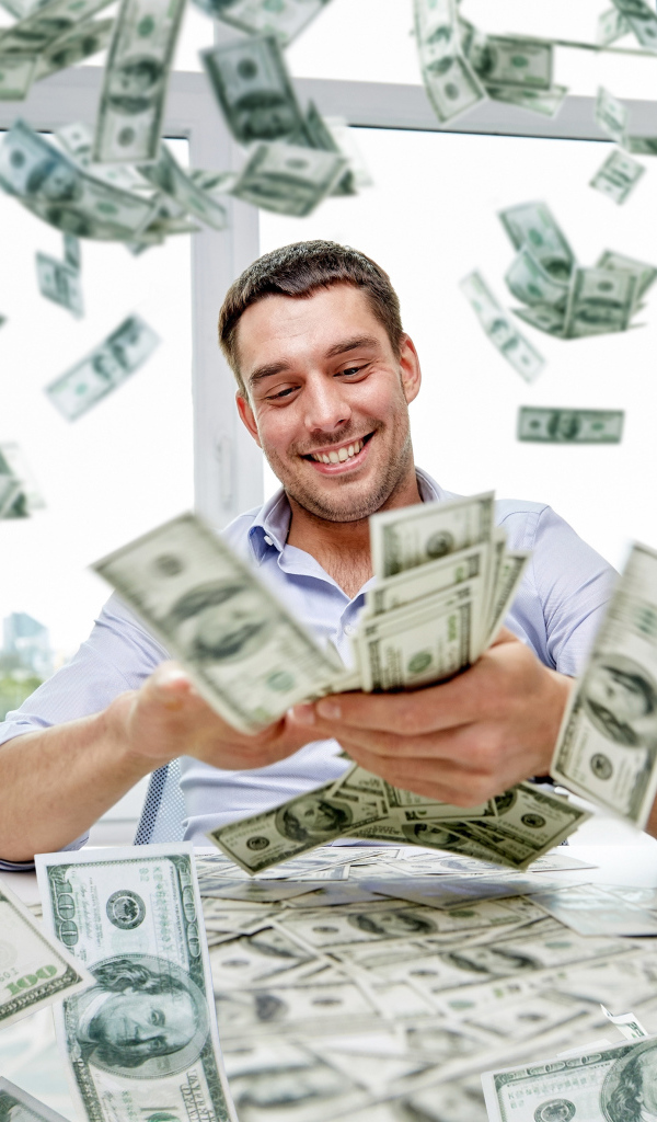 Улыбающийся мужчина разбрасывает доллары