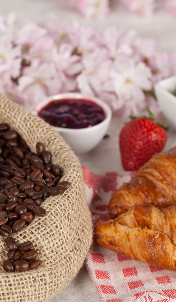 Чашка кофе в мешке с кофейными зернами и свежими круассанами