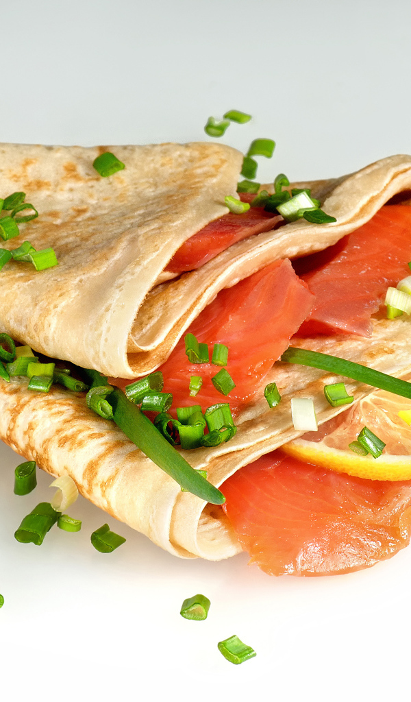 Аппетитный блин с красной рыбой и зеленым луком