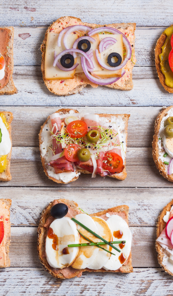 Аппетитные бутерброды на деревянном столе вид сверху