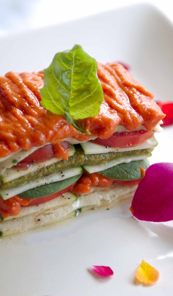 Аппетитный овощной бутерброд на белой тарелке с цветком