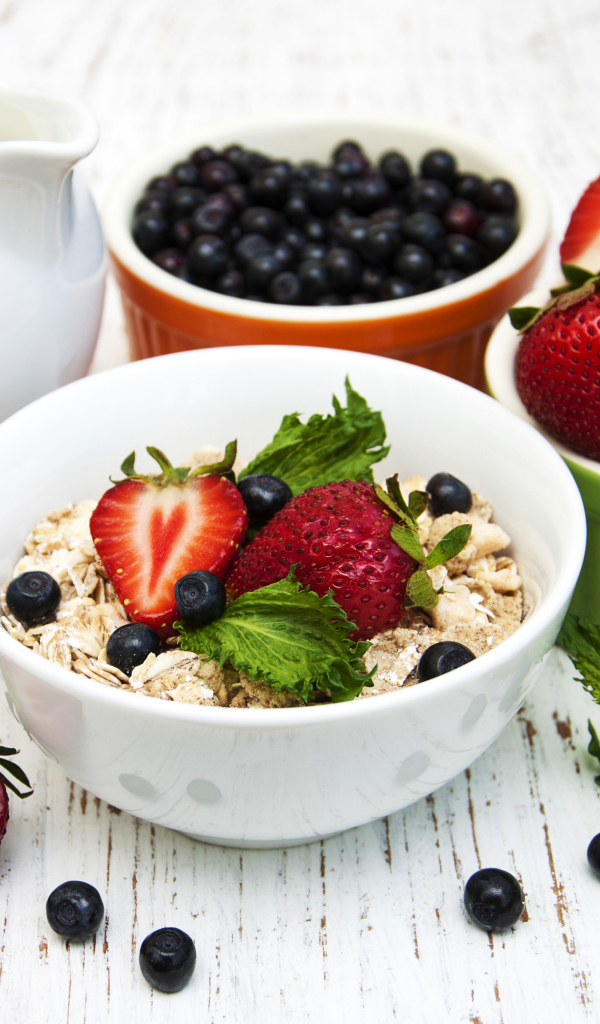 Ягоды клубники и черники на завтрак с овсяными хлопьями