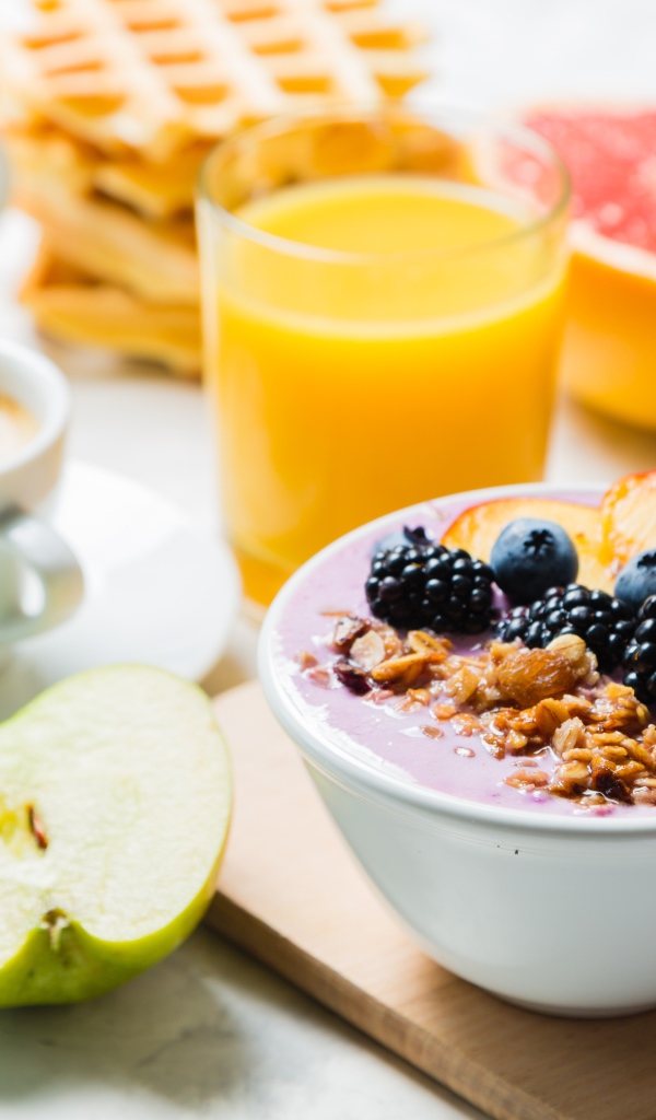 Завтрак с овсянкой, ягодами, фруктами и свежим соком на столе