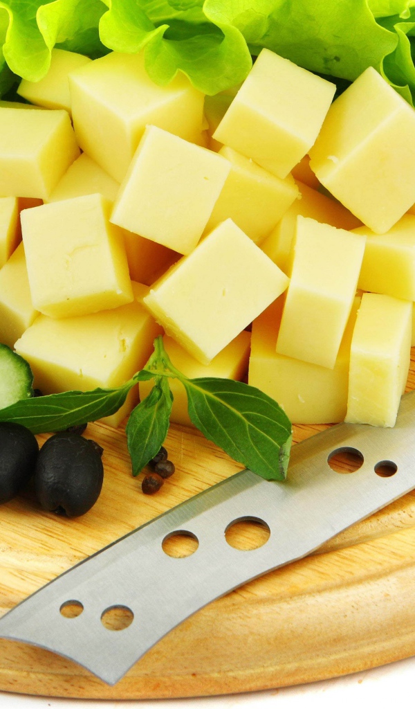 Сыр нарезанный кубиками на разделочной доске